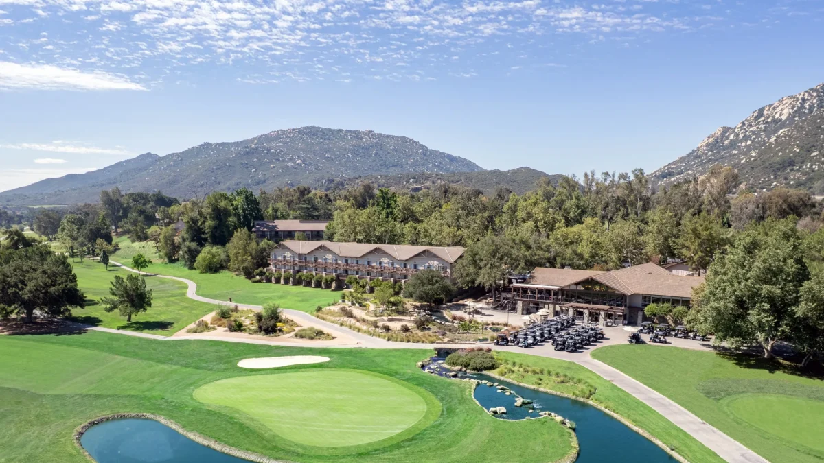 Scenic view of Temecula Creek Inn featuring lush greens, a pond, and mountains, highlighting the Chef's Garden dining experience.