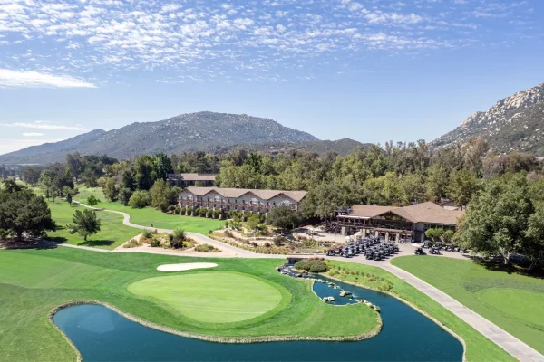 Scenic view of Temecula Creek Inn featuring lush greens, a pond, and mountains, highlighting the Chef's Garden dining experience.