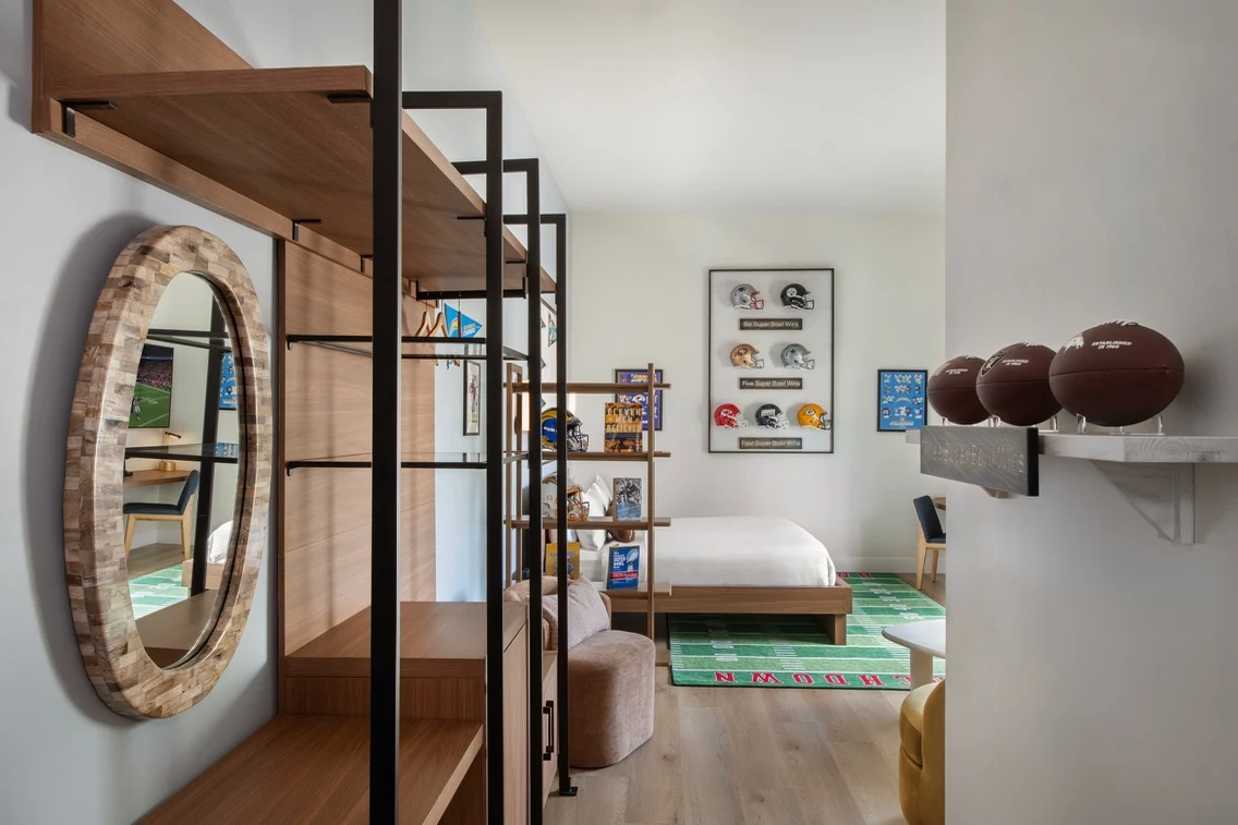 Interior view of a football-themed suite at The Anthem Hotel, featuring memorabilia, a bed, and a cozy seating area.