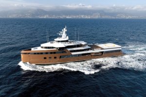 Luxury yacht LA DATCHA navigating through open waters with a city skyline in the background.