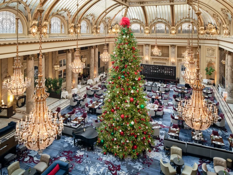 Festively decorated Christmas tree in the Garden Court of the Palace Hotel, with elegant chandeliers and tables set for brunch.