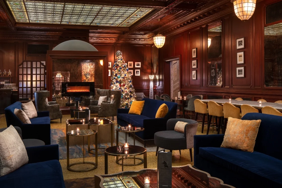 Luxuriously decorated lounge at the Palace Hotel featuring stylish seating, festive lighting, and a beautifully adorned Christmas tree.