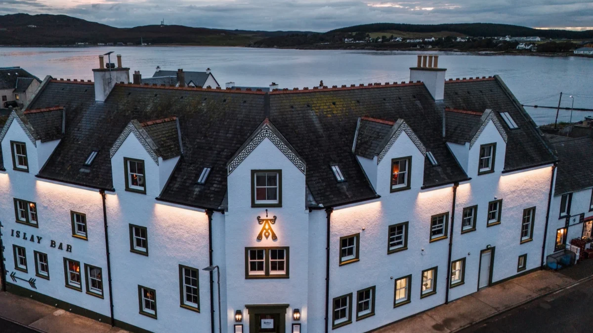 Ardbeg House, a luxury accommodation on Islay, showcases a beautifully lit white building by the water.