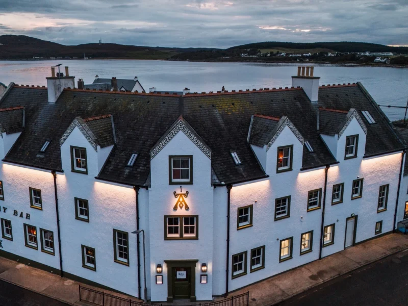 Ardbeg House, a luxury accommodation on Islay, showcases a beautifully lit white building by the water.