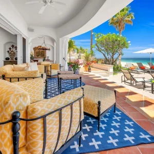 Luxurious beachfront patio in Los Cabos, featuring inviting seating, a pool, and ocean views. Perfect for winter getaways.