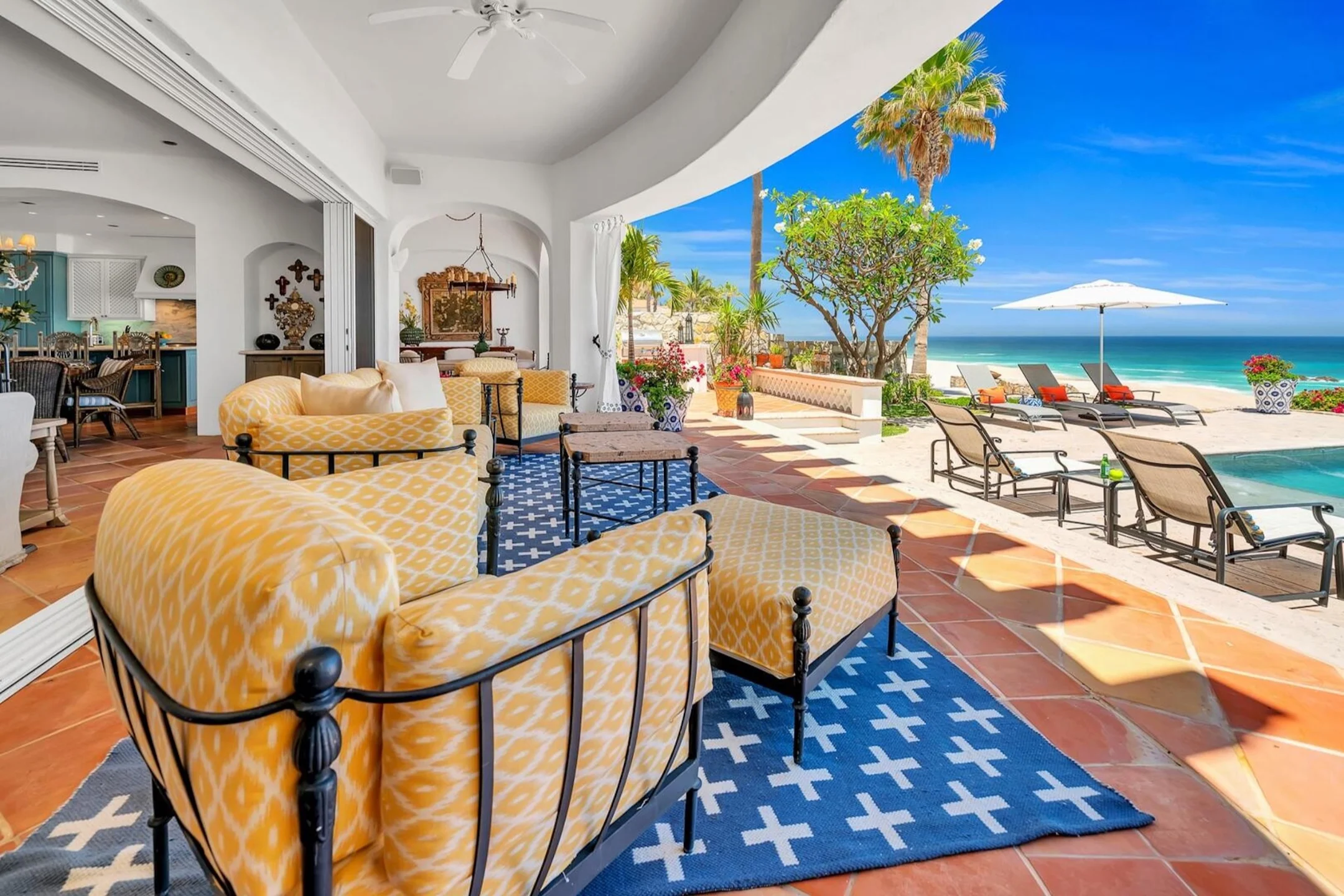 Luxurious beachfront patio in Los Cabos, featuring inviting seating, a pool, and ocean views. Perfect for winter getaways.