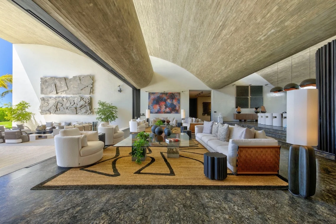Luxurious living room in Punta Cana villa featuring modern furniture, artistic decor, and an open layout with natural light.