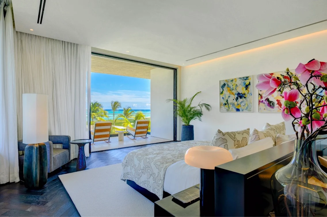 Luxurious second bedroom featuring elegant decor, a view of the beach, and access to a private terrace.