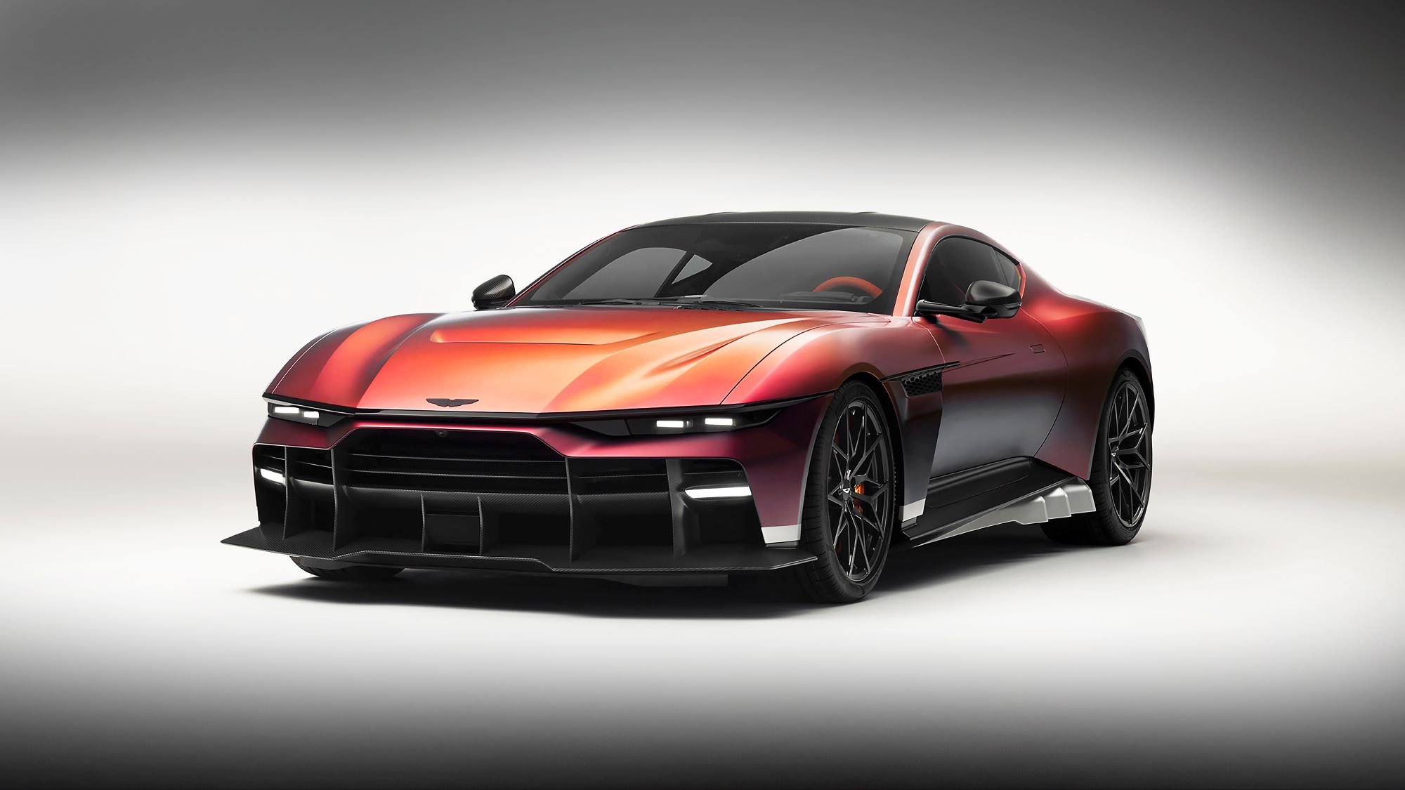 Aston Martin Valen showcasing a sleek design with a vivid red exterior and aggressive stance, highlighting its V12 supercar performance.