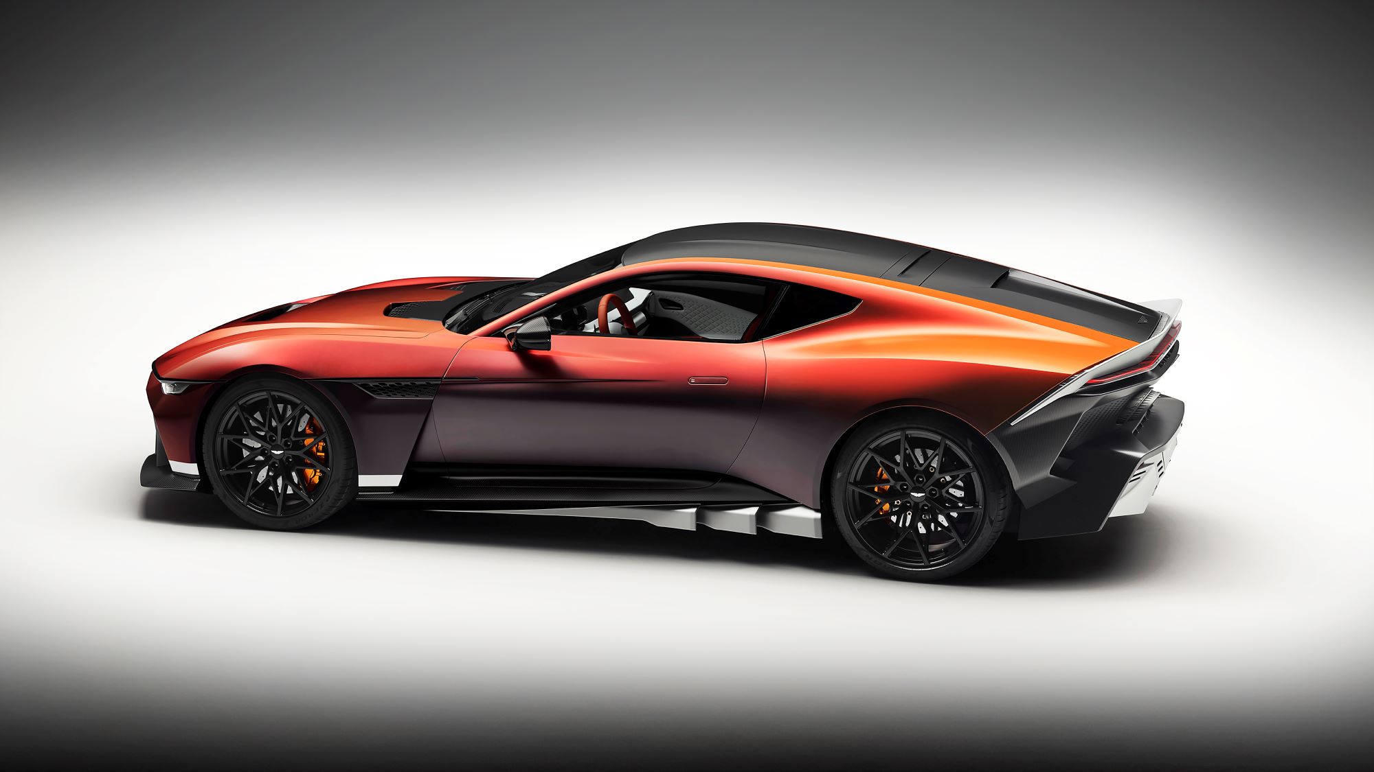 Aston Martin Valen showcased in a striking orange and black color scheme, emphasizing its sleek design and high performance.