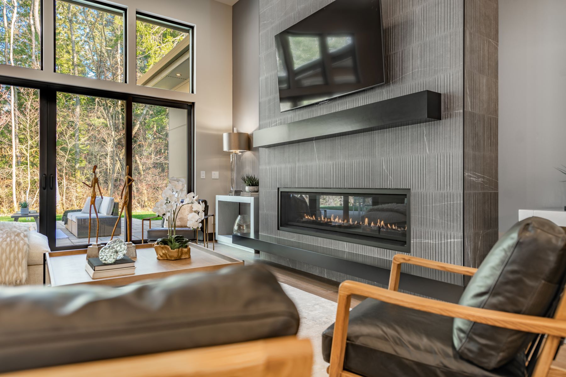 Modern living room featuring a gas fireplace, large windows, and stylish furniture, ideal for busy homeowners.