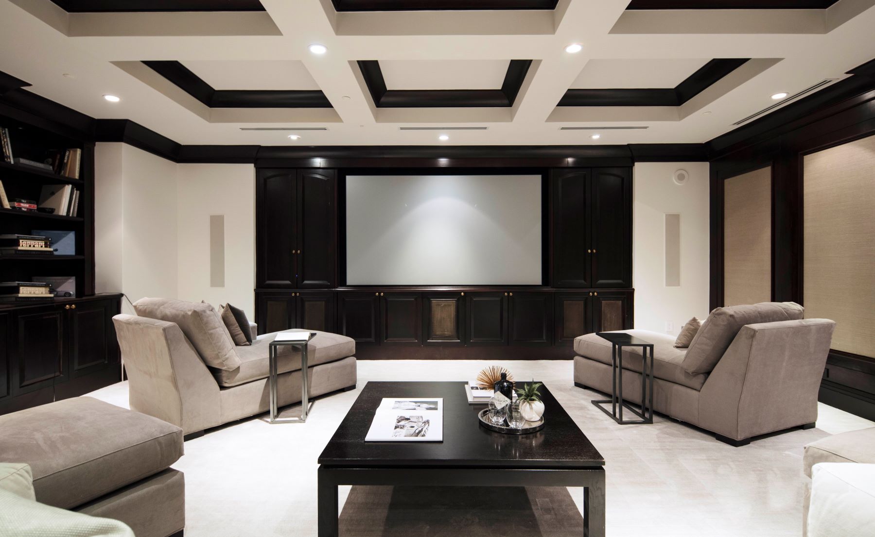 Modern living room featuring plush sofas, a coffee table, and a large entertainment system. Ideal for relaxation and entertainment.
