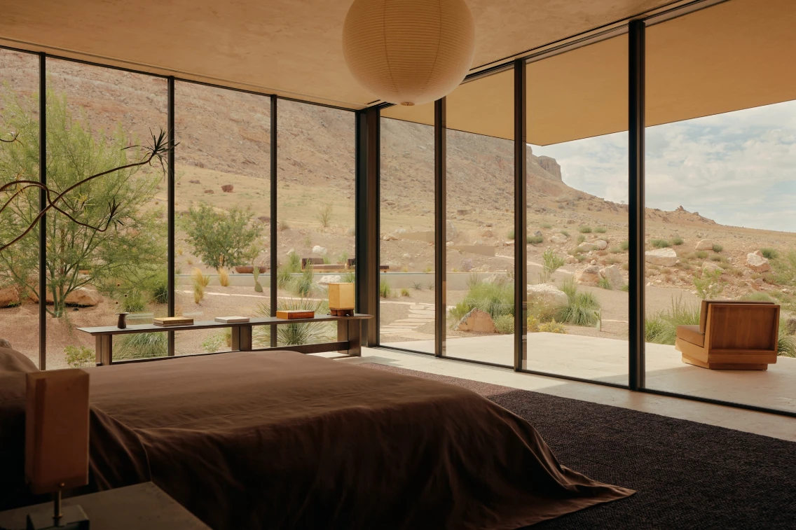 Stylish interior view of a bedroom with large windows showcasing the desert landscape outside in southern Utah.