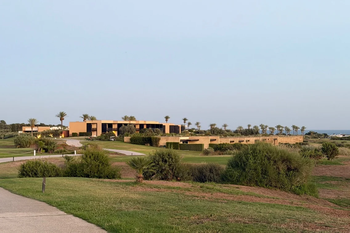 Rocco Forte’s Verdura Resort amidst lush landscaping and palm trees, overlooking the sea in a serene setting.