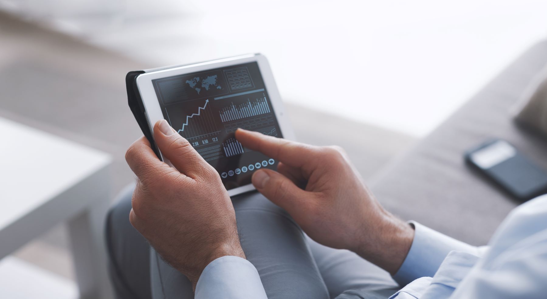 A person analyzing cryptocurrency market trends on a tablet, with graphs and data displayed on the screen.