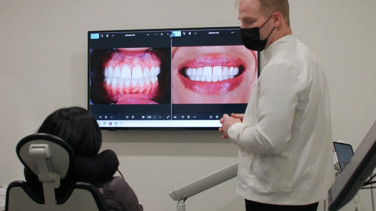 Dental professional discussing before-and-after images of dental treatments during a consultation with a patient.