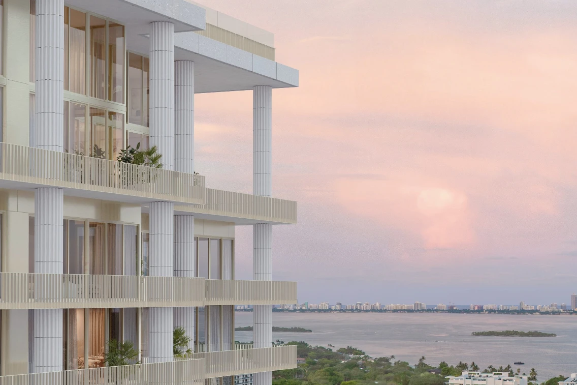 Luxury condominium balconies overlook a serene bay under a pastel sky, highlighting Miami's vibrant coastal landscape.