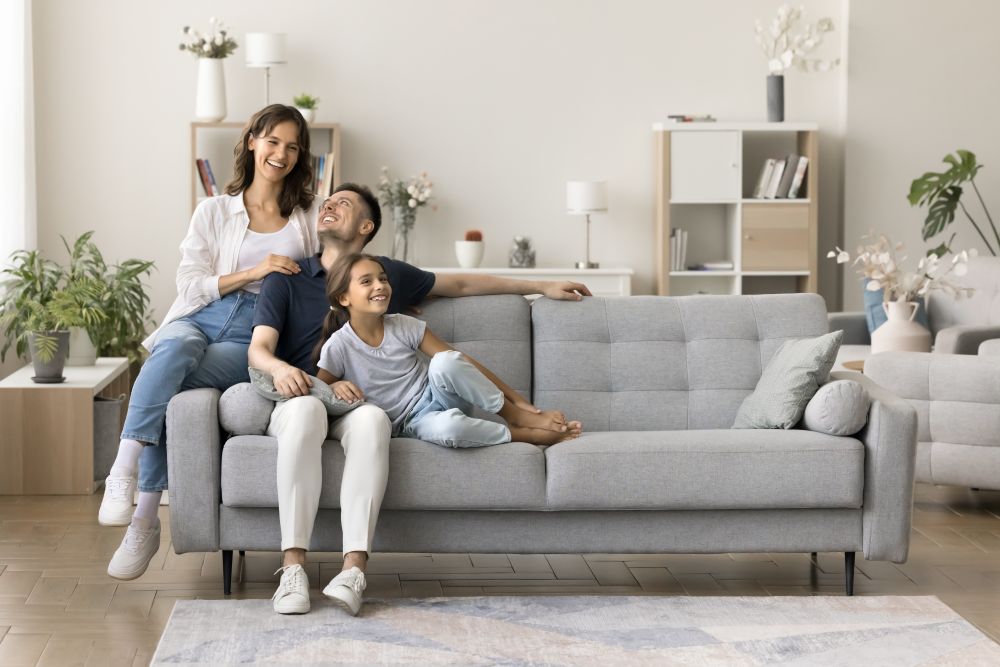 Family enjoying time together on a comfortable sofa in a bright, modern living room, highlighting the importance of interior planning.