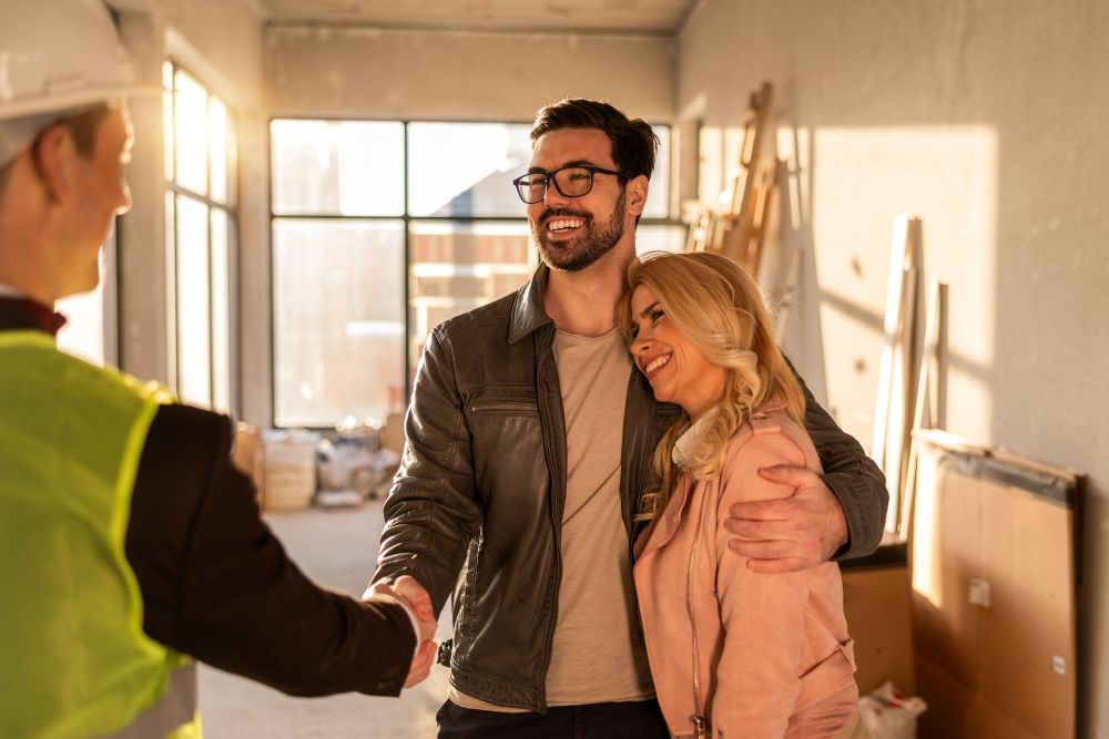 Homeowners discussing plans with a contractor in a well-lit interior space, highlighting the importance of interior planning.