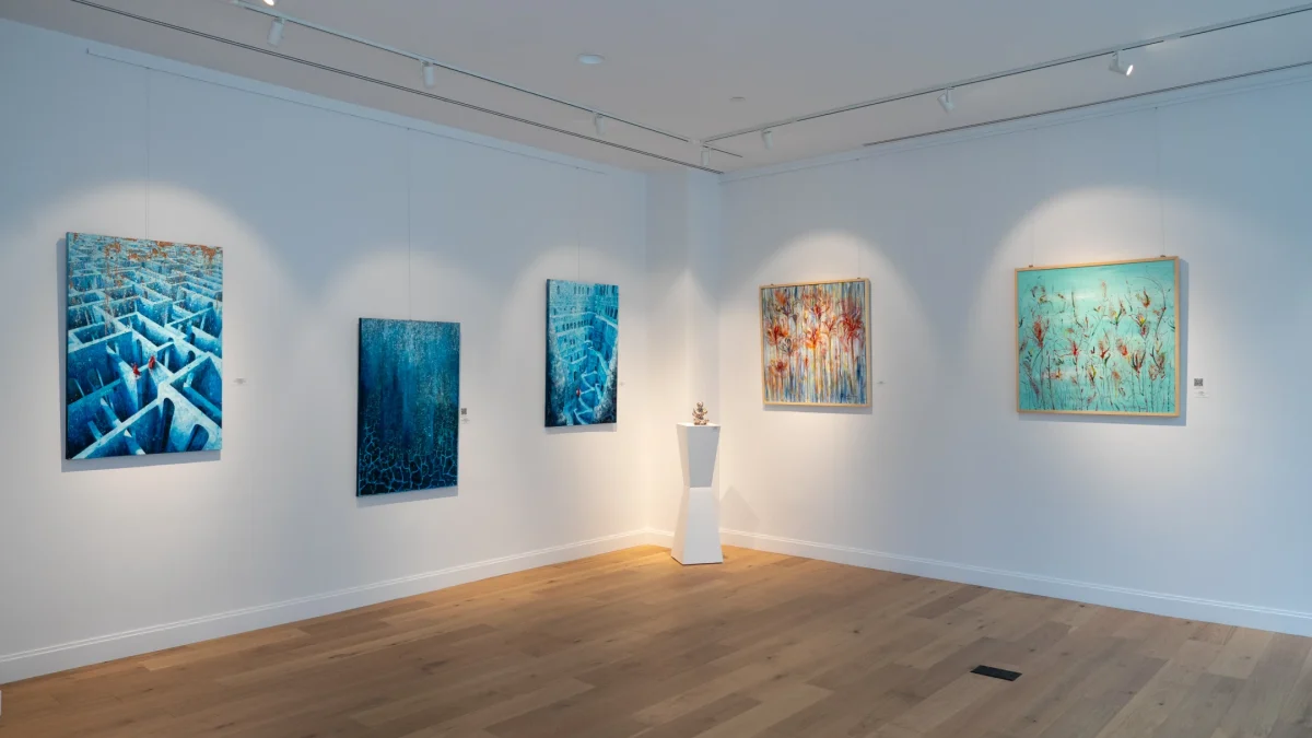 Artworks displayed in a modern gallery setting, highlighting vibrant colors and intricate designs on the walls.