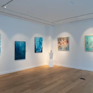 Artworks displayed in a modern gallery setting, highlighting vibrant colors and intricate designs on the walls.