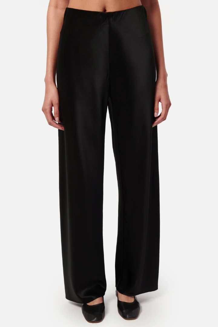 Sleek black wide-leg trousers styled with a fitted waistband, ideal for autumn outfits.