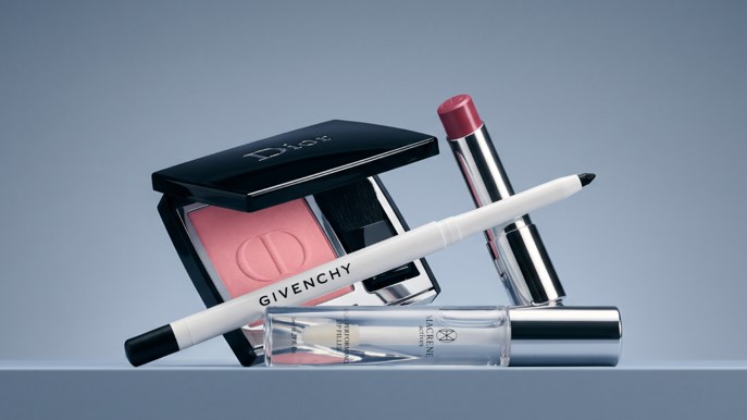 Luxury makeup products including blush, lipstick, and eyeliner displayed on a sleek surface.
