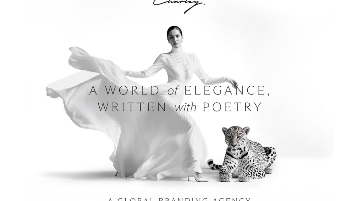A woman in a flowing white dress stands next to a leopard, with elegant text highlighting luxury branding.