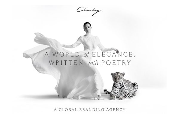 A woman in a flowing white dress stands next to a leopard, with elegant text highlighting luxury branding.