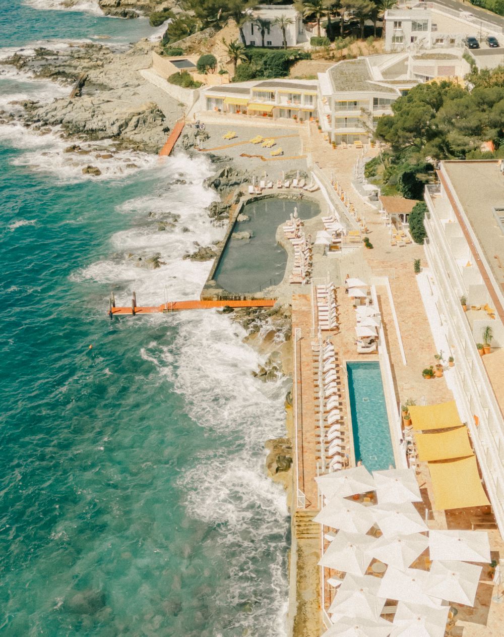 Overlooking the Mediterranean, Les Roches Rouges features seaside pools, sunbathing areas, and lush landscapes.