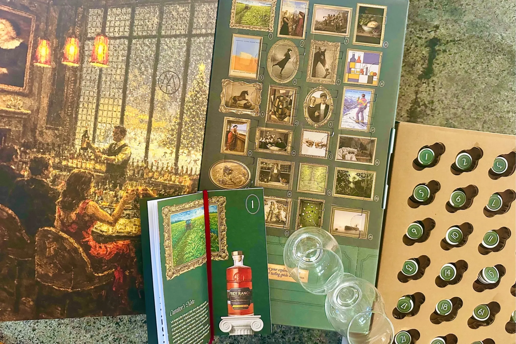 A whiskey tasting gift set featuring glasses, a guidebook, and illustrated cards displayed on a textured surface.