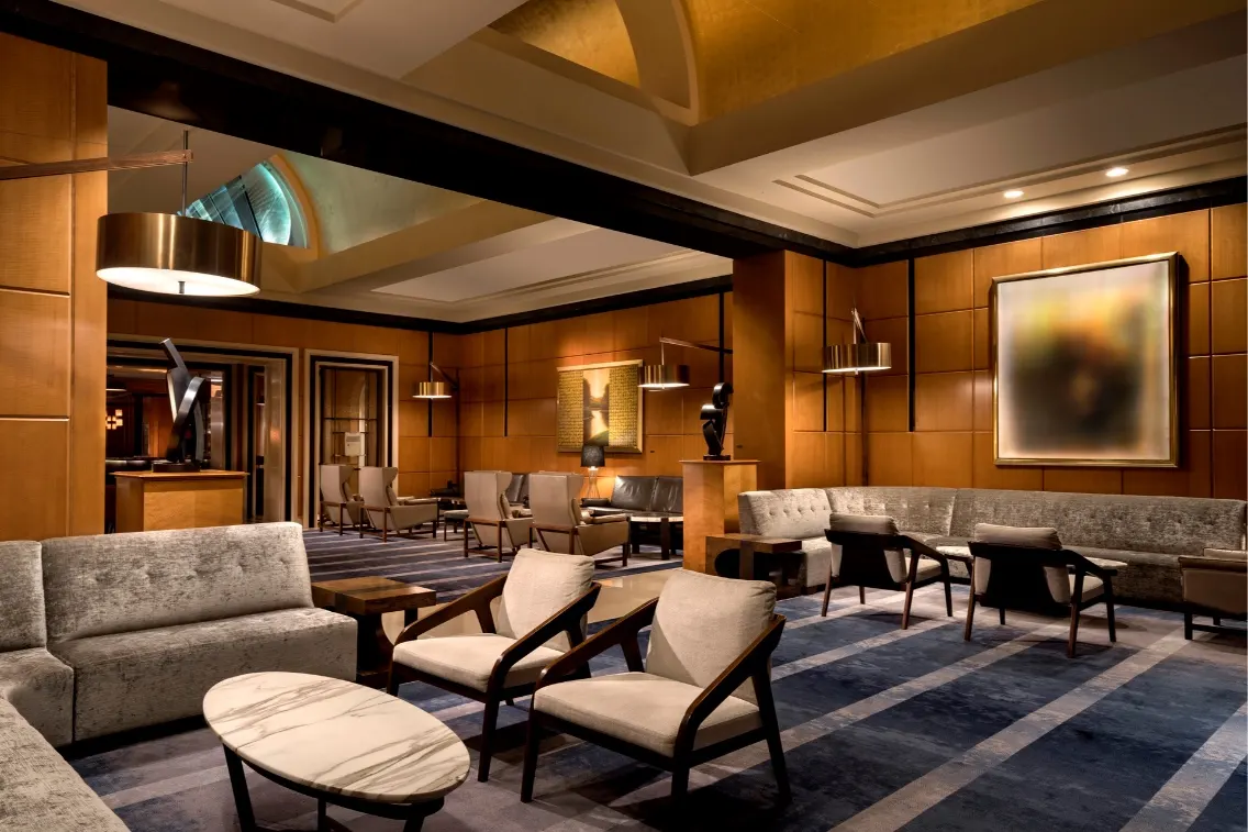 Stylish hotel lobby featuring modern seating, decorative lighting, and wood panel accents, inviting guests to relax.