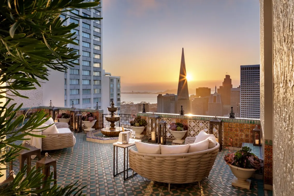 Penthouse terrace at the Fairmont San Francisco, featuring a stunning sunset view over the city skyline and the Transamerica Pyramid.