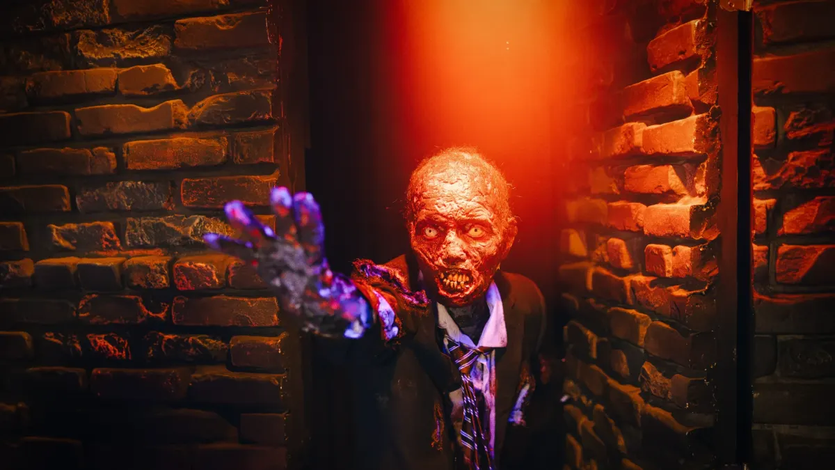 A zombie figure reaching out with a sinister expression against a dimly lit brick wall, perfect for Halloween themes.