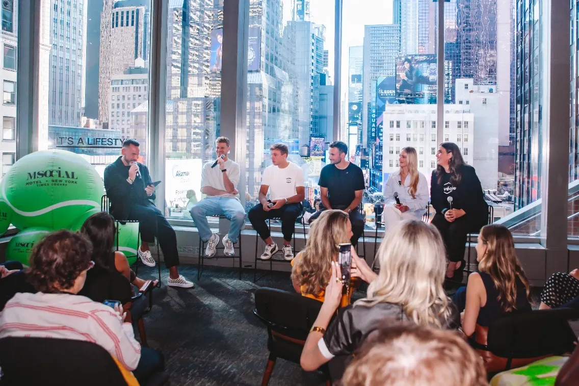 Panel discussion at M Social Times Square with city views, showcasing vibrant New York energy and diverse speakers.