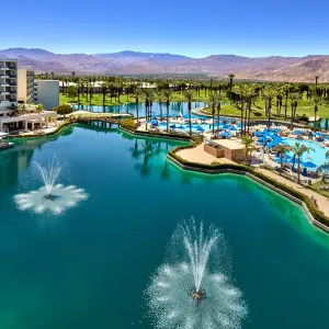 JW Marriott Desert Springs Resort features a poolside view with fountains, palm trees, and mountains in the background.