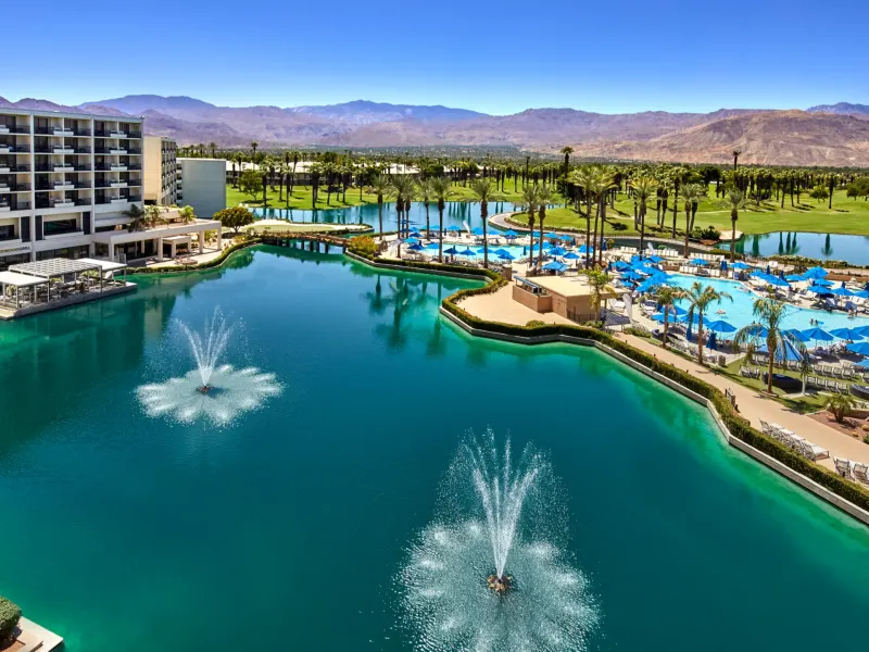 JW Marriott Desert Springs Resort features a poolside view with fountains, palm trees, and mountains in the background.