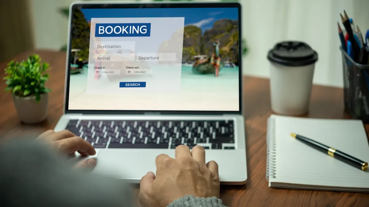 User interacting with a laptop booking system for luxury multi-destination vacation planning.