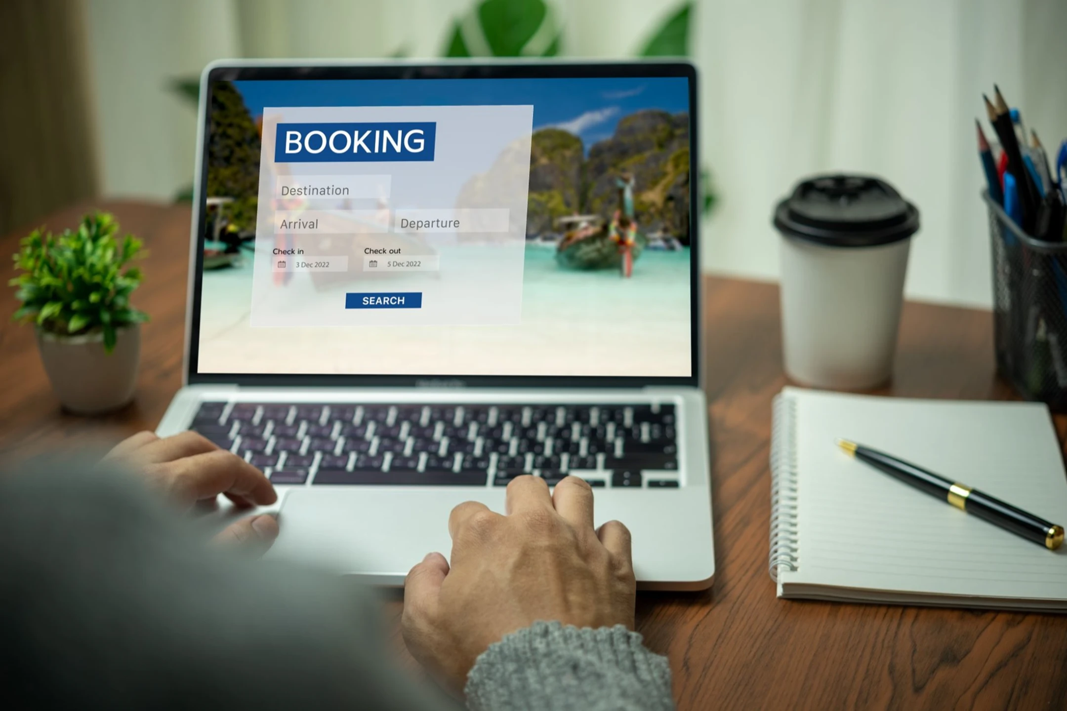 User interacting with a laptop booking system for luxury multi-destination vacation planning.