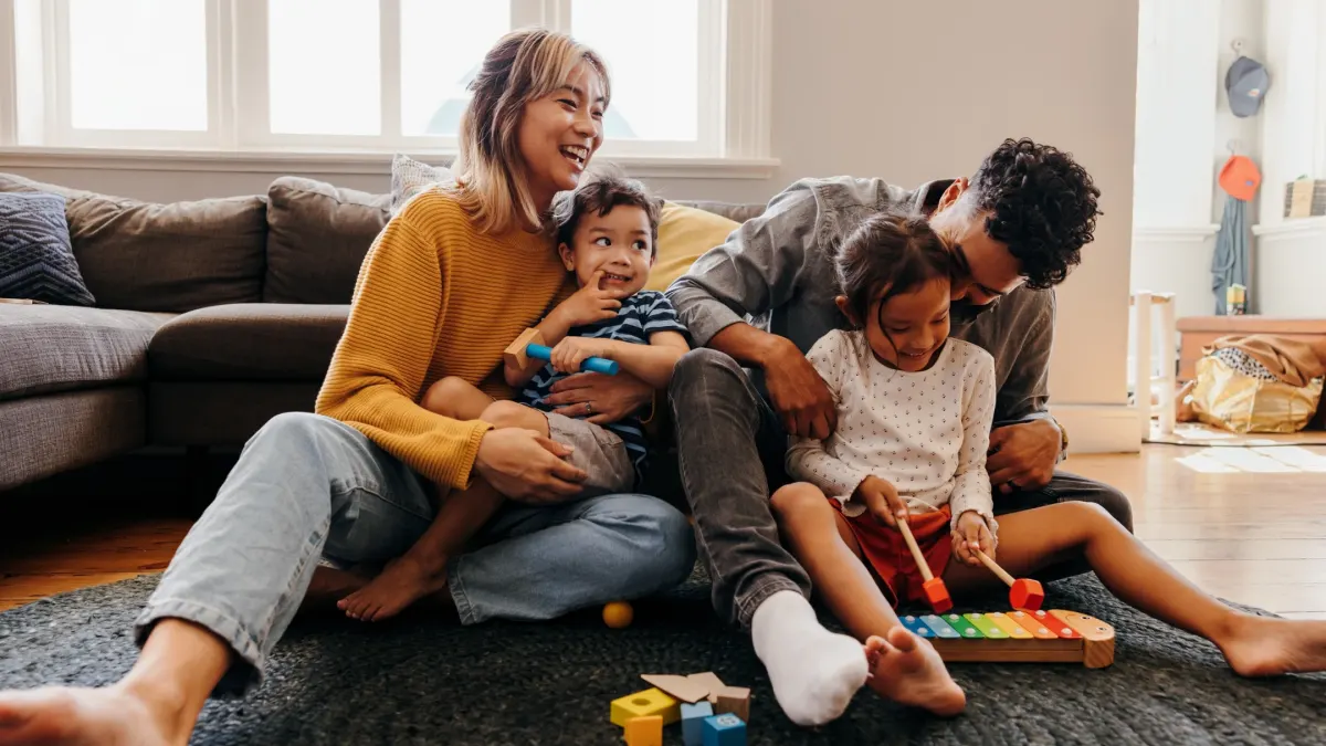 A happy family plays together on the floor, engaging with toys and enjoying quality time during a cozy afternoon.