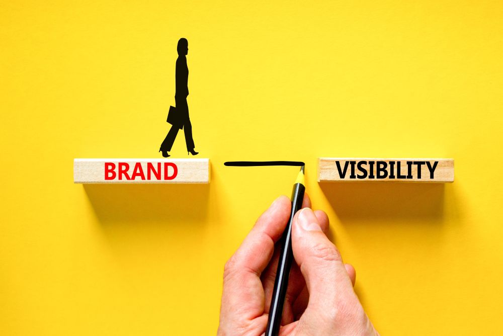A person walking on a block labeled "BRAND" while connecting it to a block labeled "VISIBILITY" with a pencil.