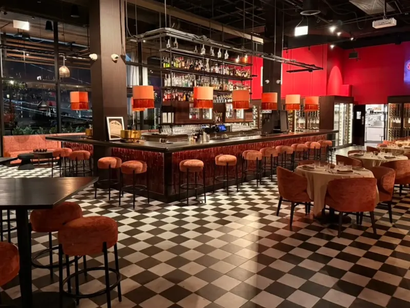 Interior of Christian's Wine Bar featuring a stylish bar, seating areas, and a striking checkerboard floor design.