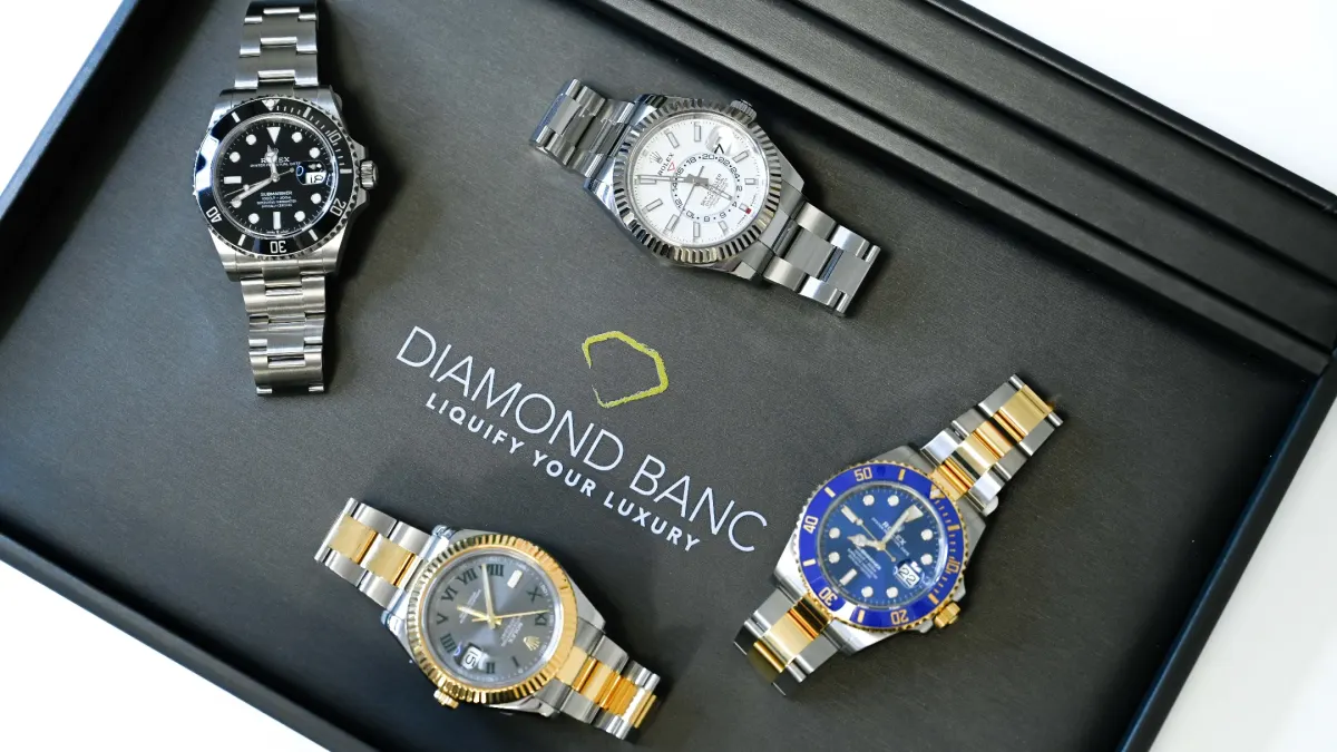 Four luxury Rolex watches displayed in a black box featuring the Diamond Banc logo, highlighting luxury timepieces.
