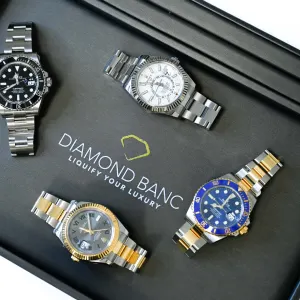 Four luxury Rolex watches displayed in a black box featuring the Diamond Banc logo, highlighting luxury timepieces.