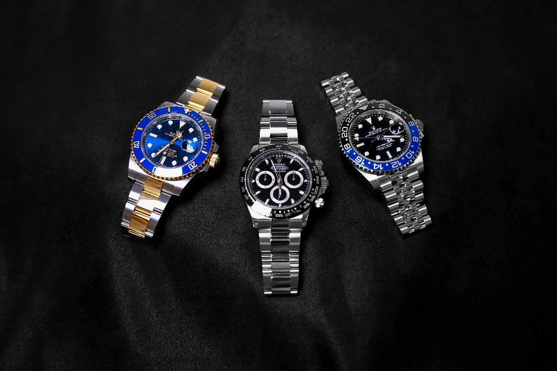 Three luxury Rolex watches on a dark background, showcasing their elegant designs and distinctive features.