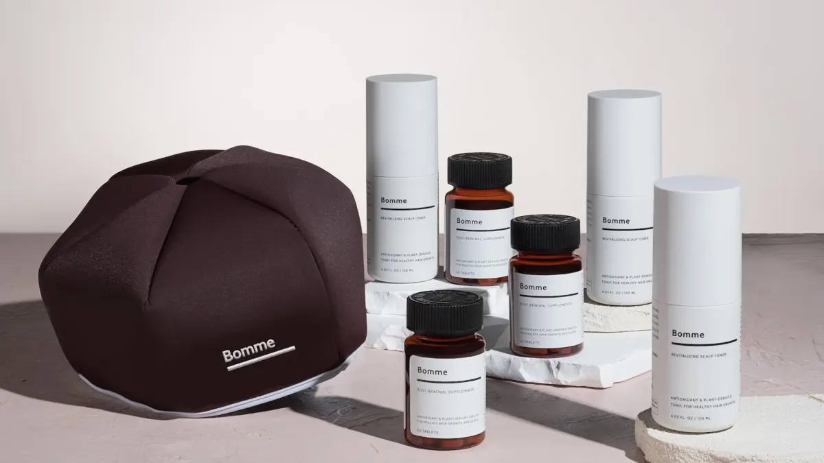 Bomme hair wellness products including scalp toner and dietary supplements displayed on a neutral surface.
