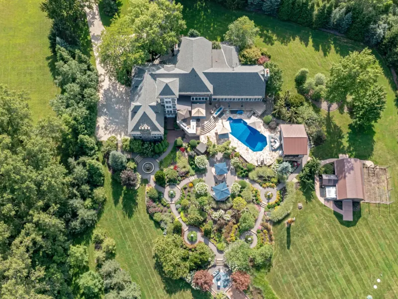Aerial view of a spacious property featuring a landscaped garden, pool, and a large home in Richfield, Ohio.