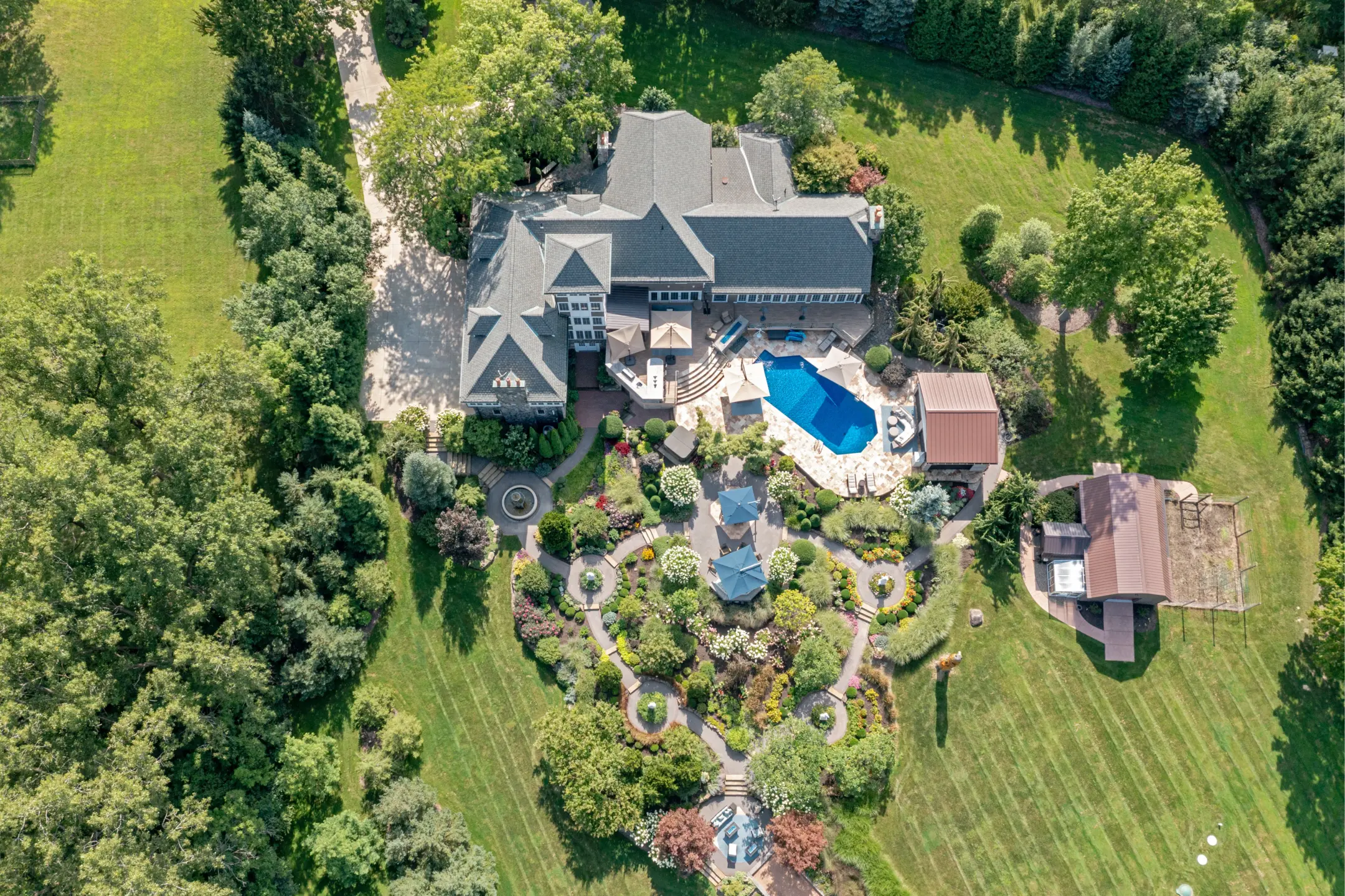 Aerial view of a spacious property featuring a landscaped garden, pool, and a large home in Richfield, Ohio.