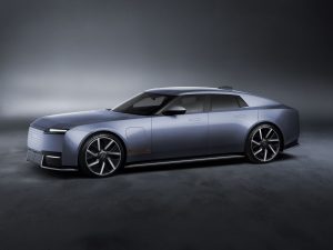 Jaguar Type 01 in a sleek blue finish, showcasing luxury design and performance features in a dimly lit studio setting.