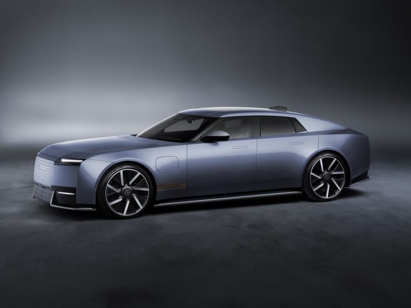 Jaguar Type 01 in a sleek blue finish, showcasing luxury design and performance features in a dimly lit studio setting.